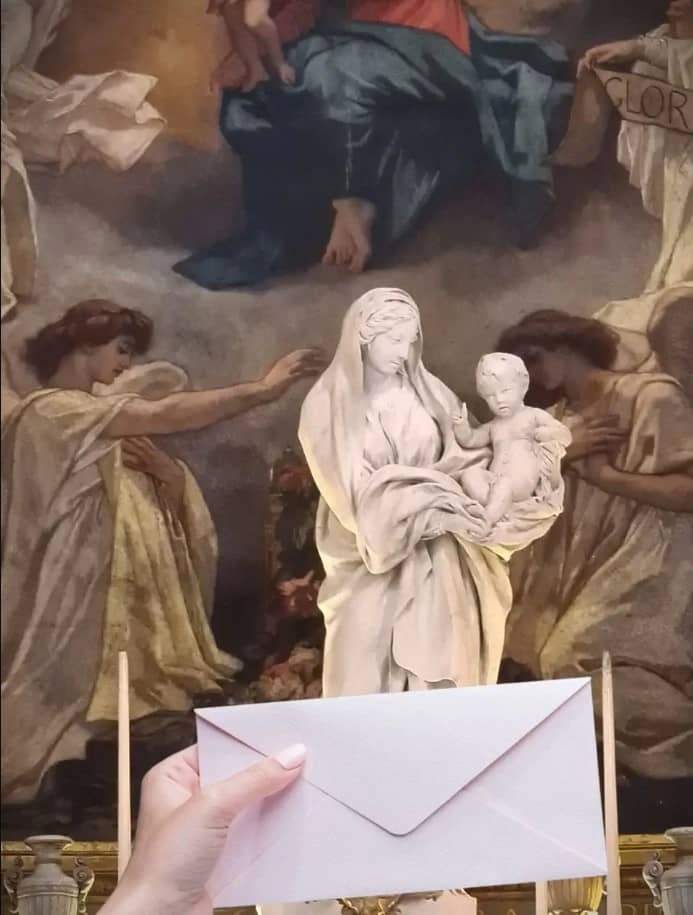 statue de la vierge marie avec une enveloppe de message